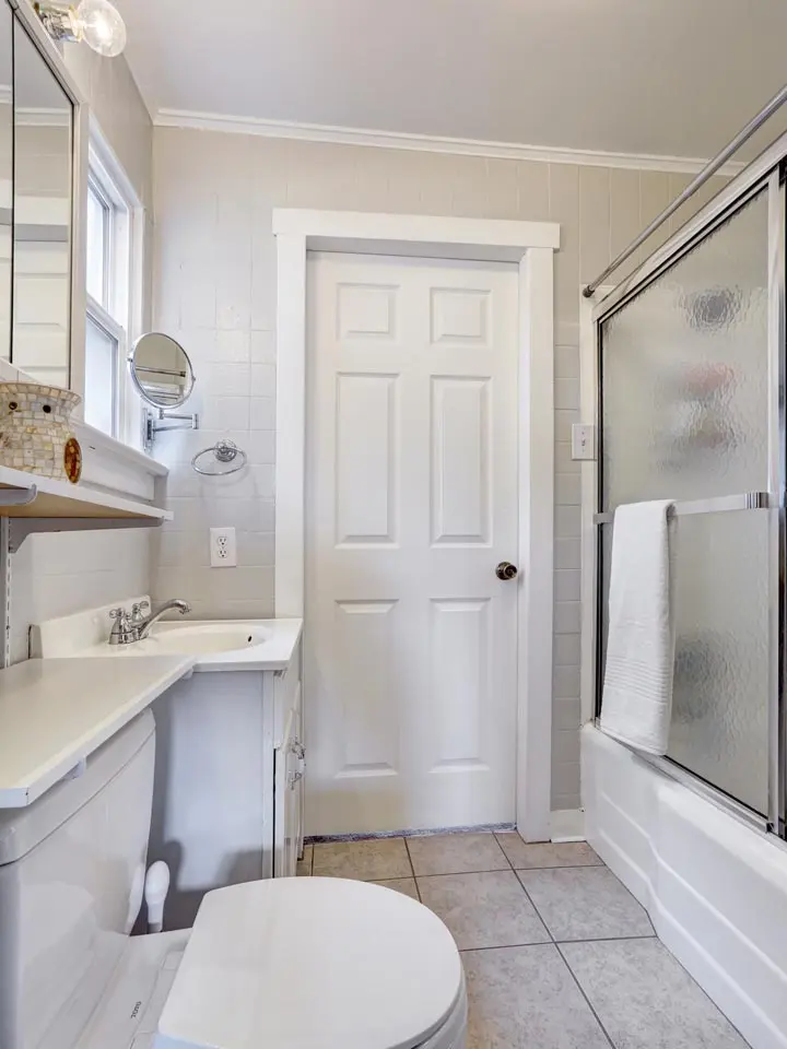 Refitted bathroom with bath, shower screen and fresh tiling