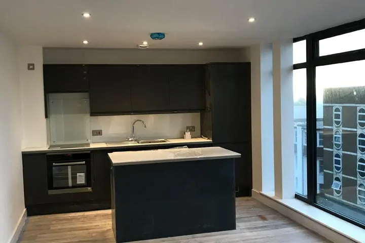 Dark kitchen with island and floor-to-ceiling windows