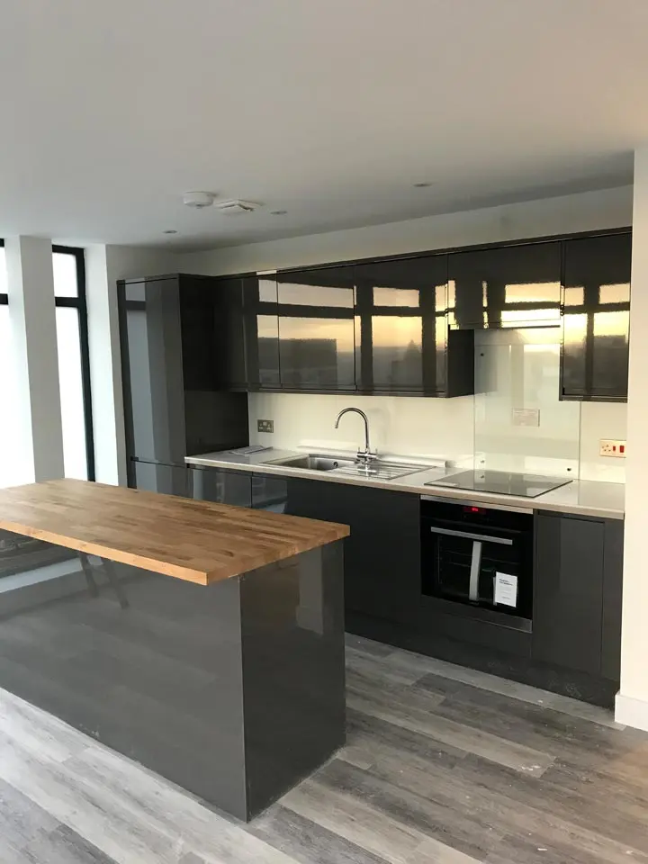 Dark fitted kitchen with oak worktop in a new build