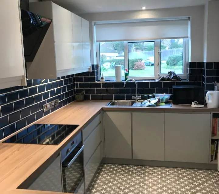 Finished kitchen with navy metro tiles and oak worktops