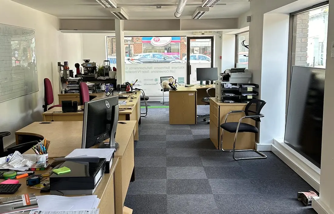 Open-plan office refurbished with new carpet tiles and large windows