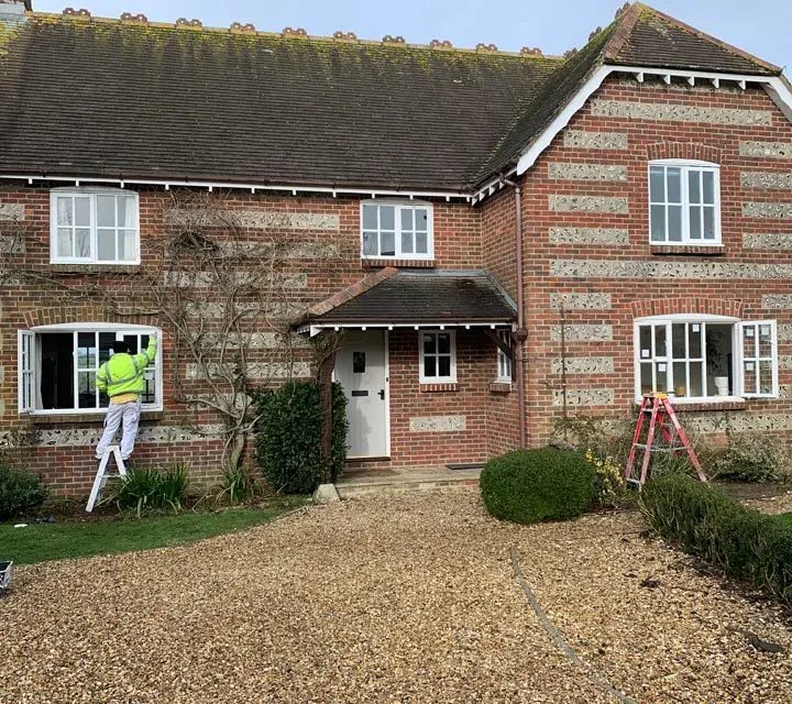 Double glazed windows being replaced on a brick cottage